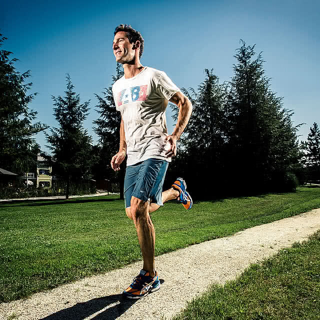 Ein Mann joggt auf einem sonnigen Naturpfad nahe dem Genussdorf Gmachl – perfektes Laufen in Salzburg inmitten idyllischer Landschaft.