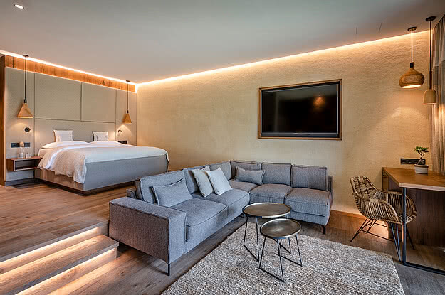 Stilvolles Hotelzimmer im Genussdorf Gmachl mit gemütlicher Couch und modernem Design.