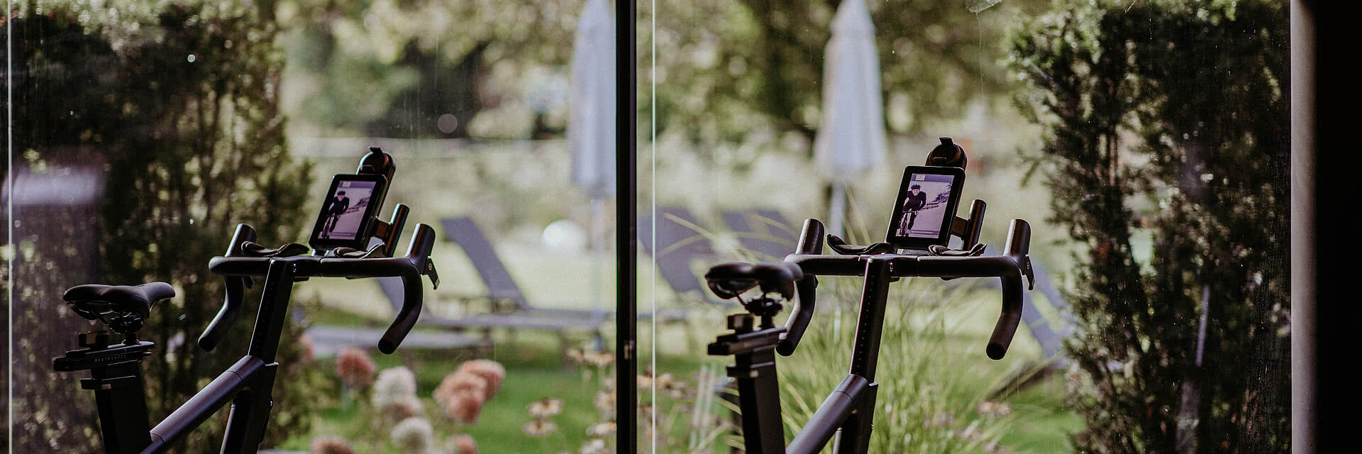 Moderne Indoor-Cycling-Bikes im Genussdorf Gmachl mit Blick ins Grüne.